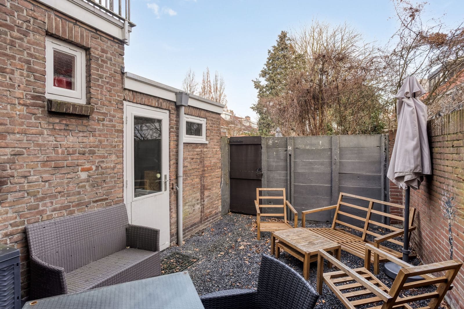 Omheinde achtertuin met terras en berging